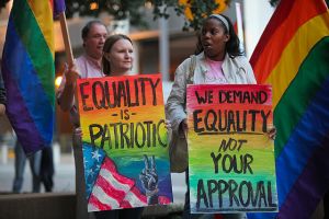 Two women hold signs protesting for LGBT equality