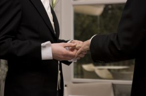 A man putting a ring on another man's finger