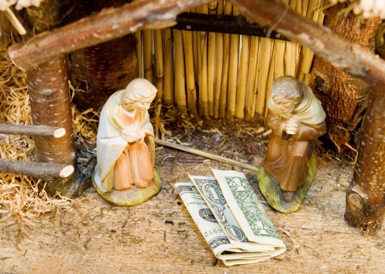 Money in a manger in place of Jesus Christ