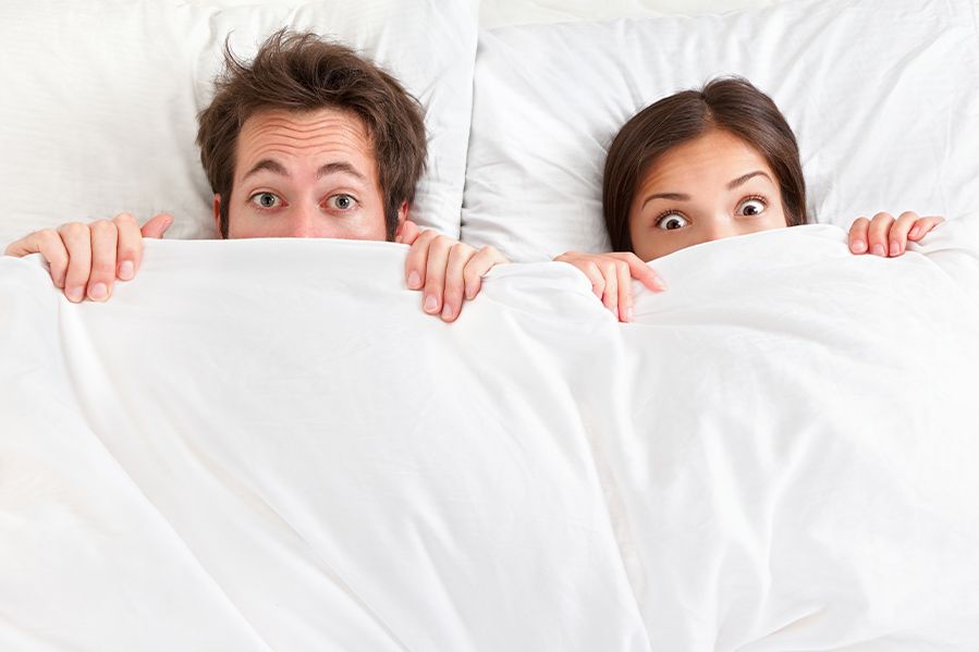 mormon couple in bed looking shocked