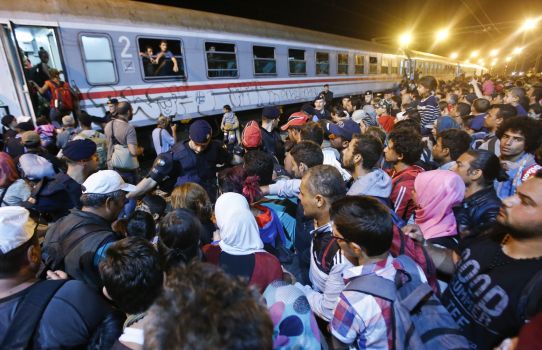 Migrants jockey for spots on a train headed for Europe