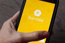 woman's hand holding smart phone with bumble app open