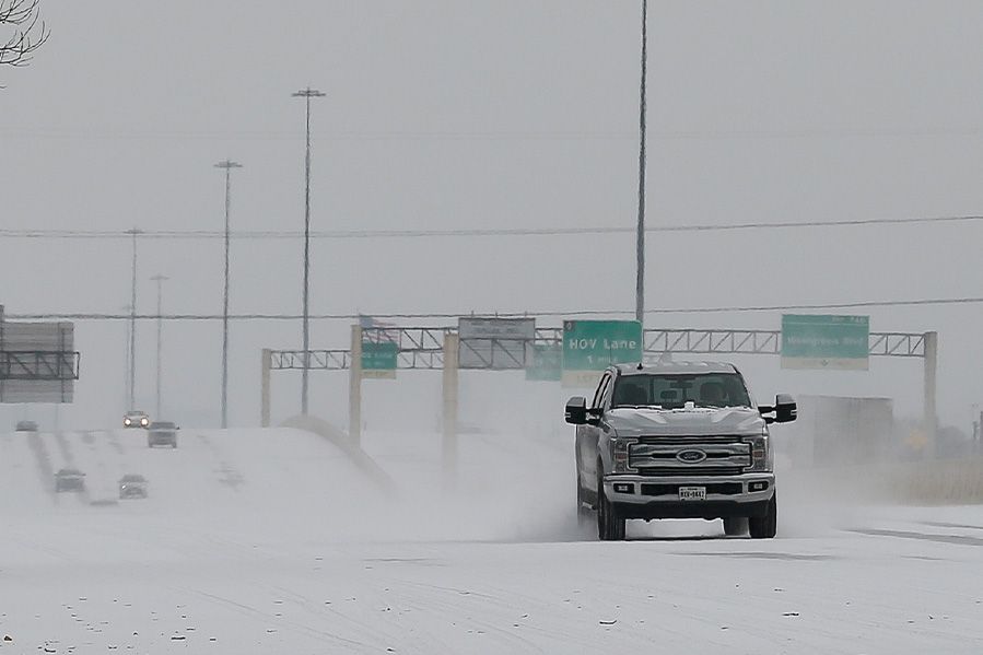 pickup truck driving in Texas snowstorm