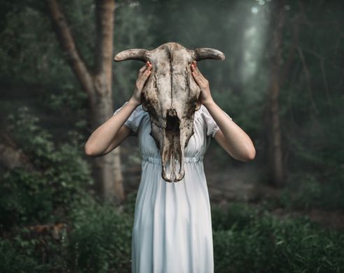 woman in forest wearing cow skull