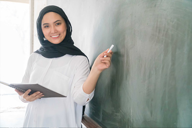 A woman in a hijab teaching at school