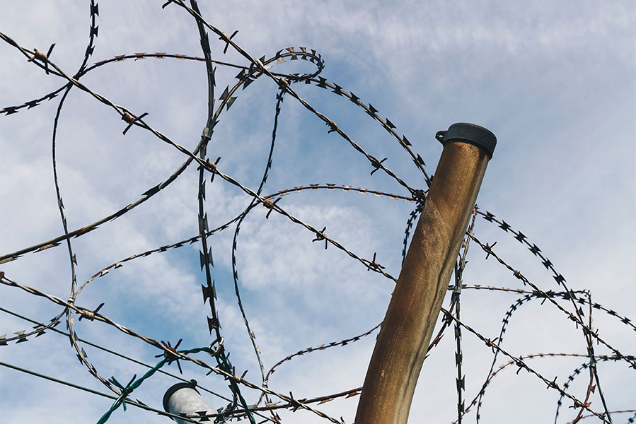 A barbed wire fence at the U.S. / Mexico border