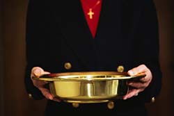 Christian pastor holding  gold-plated donation plate