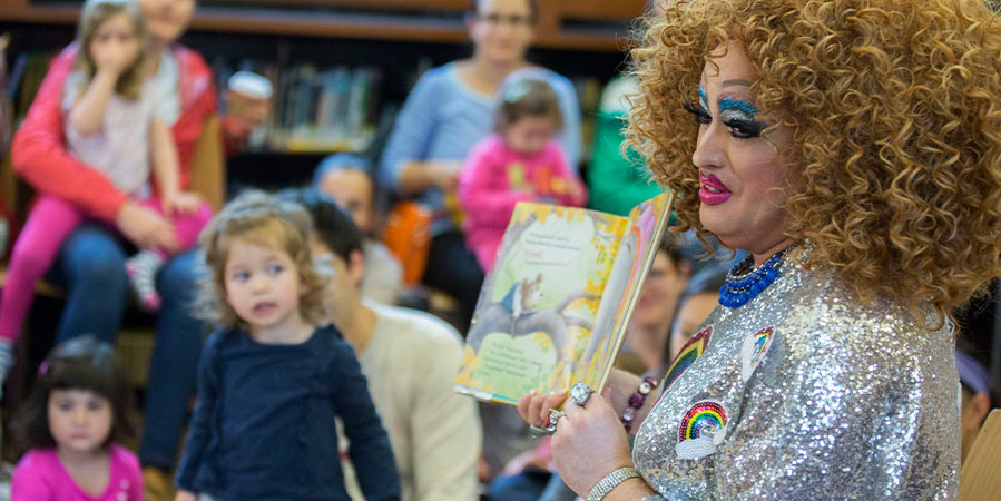 A drag queen reads a book to kids at drag queen story hour