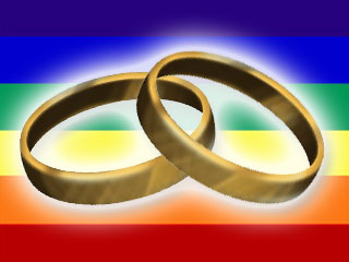 wedding rings in front of gay pride flag