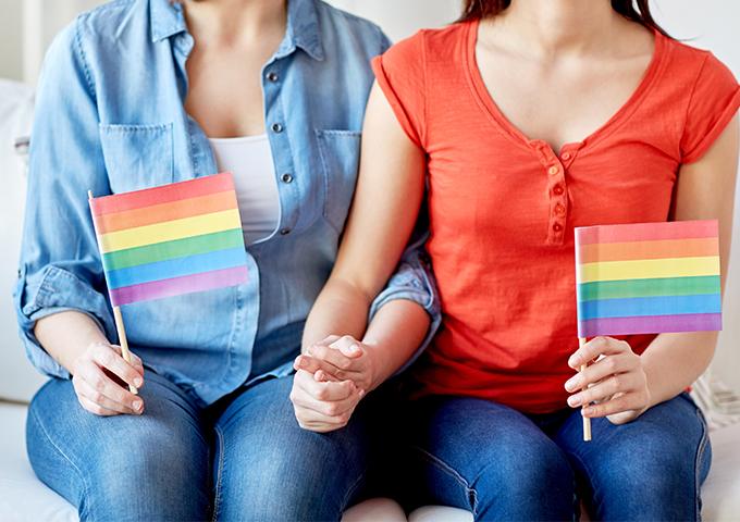 Lesbian couple holding rainbow flags