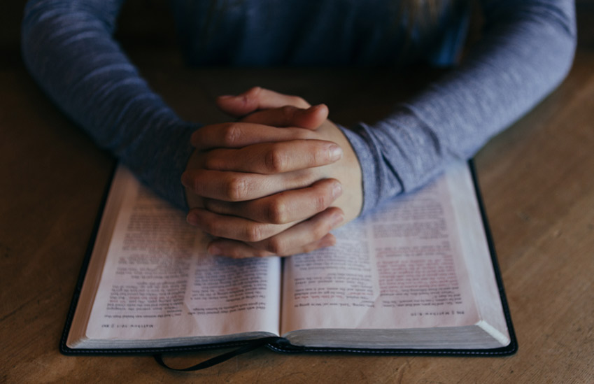 A man praying over the Bible