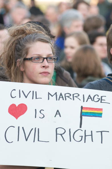 protesting woman holding sign that says civil marriage is a civil right