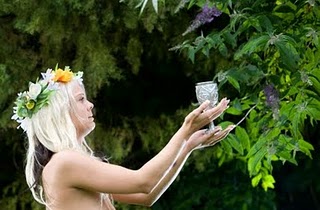 pagan priestess holding cup up to tree