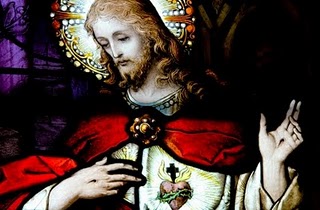 stained glass of jesus pointing at his heart