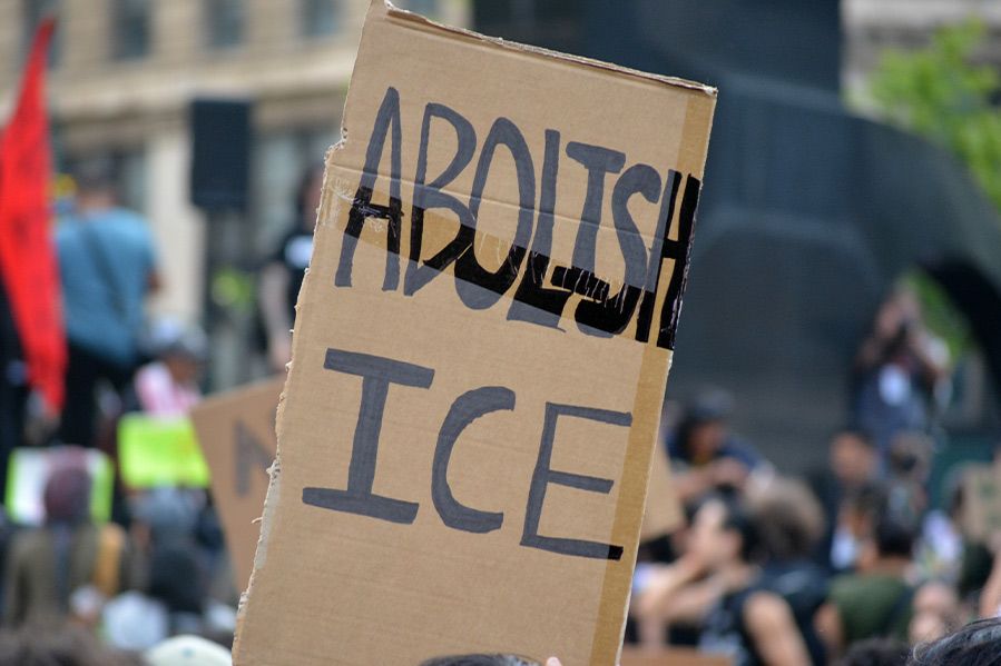 cardboard sign reading 'abolish ice' at protest