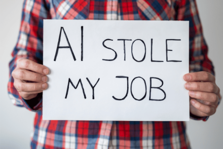 Person holding a handwritten sign that reads AI stole my job