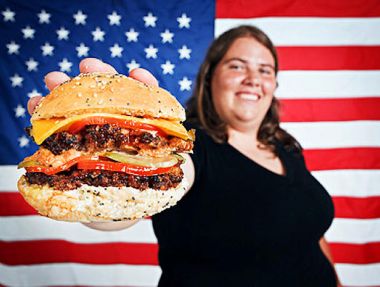 An overweight American holding a cheeseburger