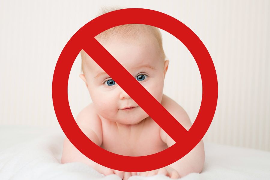 cute baby with 'no' sign over face