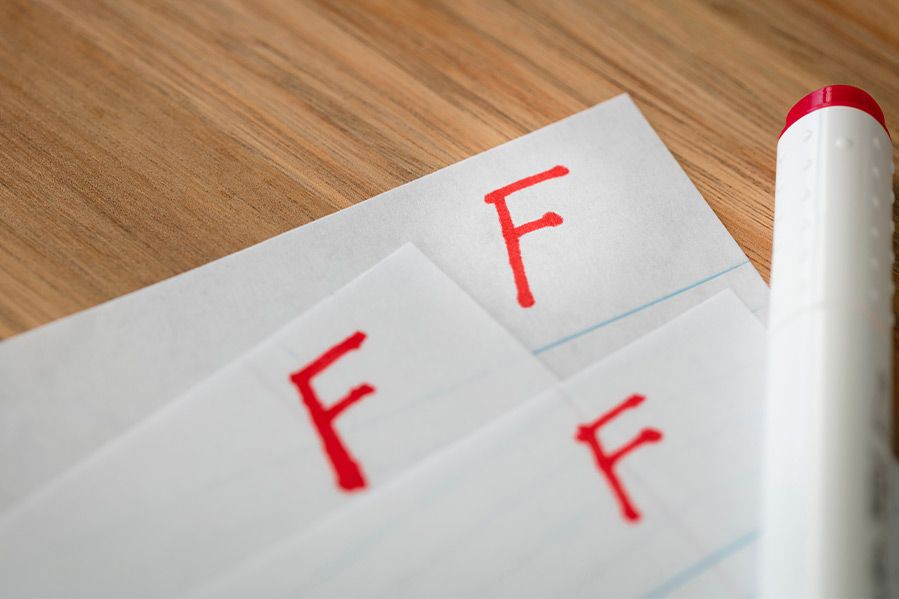 three sheets of paper with F grade on them in red ink