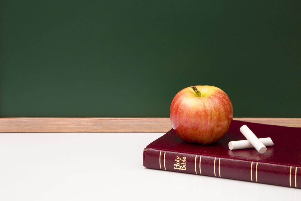 A bible next to a classroom chalkboard