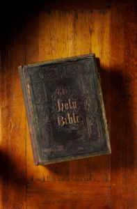 old leather bound holy bible on wooden table