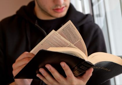 A young student reading the Bible