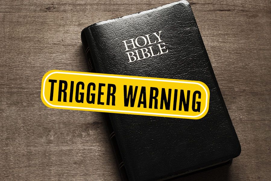 holy bible on table with yellow trigger warning label in front