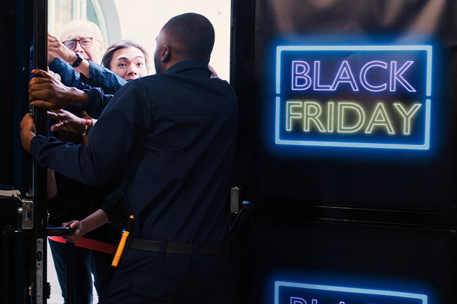 retail worker stopping customers at door during black friday