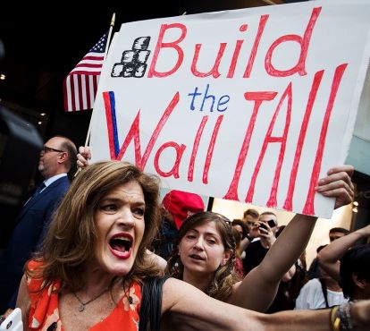 Women holding build the wall sign