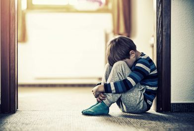 A neglected child sitting on the floor