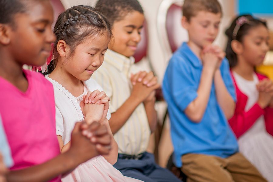 children praying in school