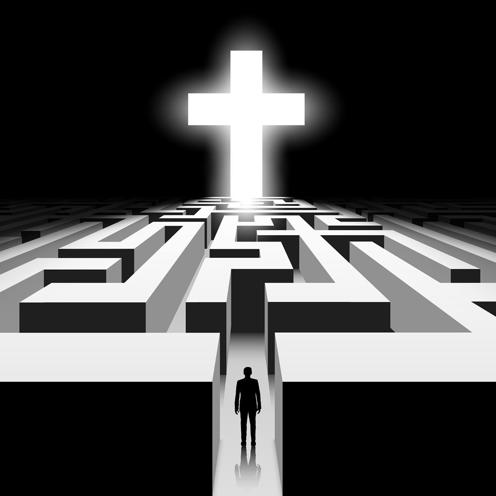 A man facing a maze with a Christian cross at the center
