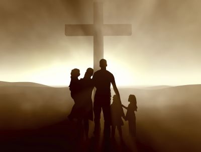 A Christian family standing before a cross