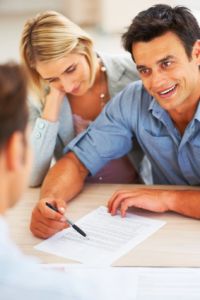 newlywed couple signing wedding license and paperwork