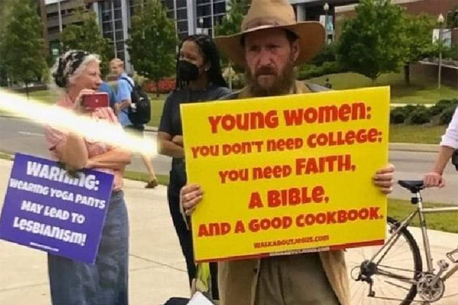 campus preacher holding anti-female sign
