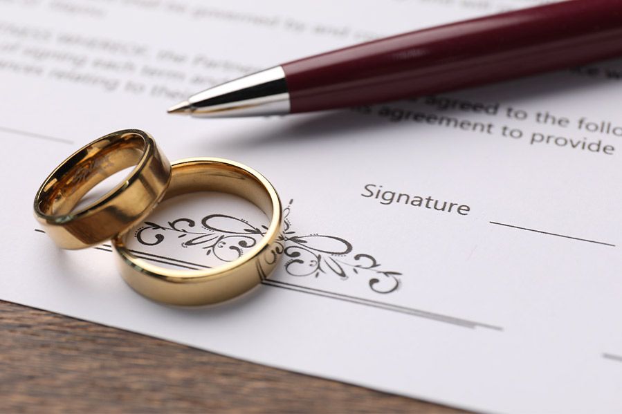 wedding rings and pen on covenant marriage contract