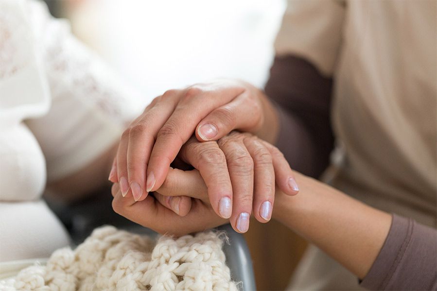 hospital patient holding hand of family member