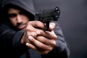 criminal in hoodie aiming handgun
