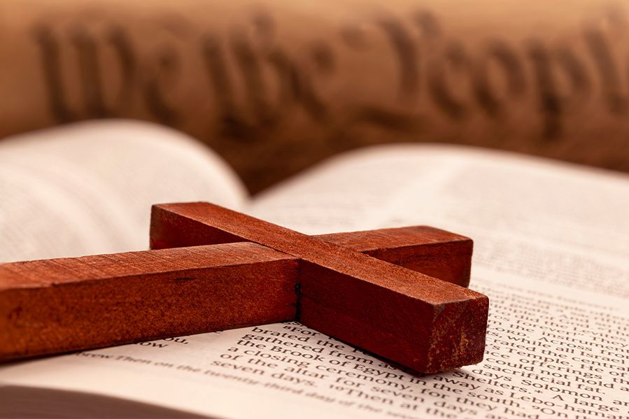 cross laying on bible with US constitution in background