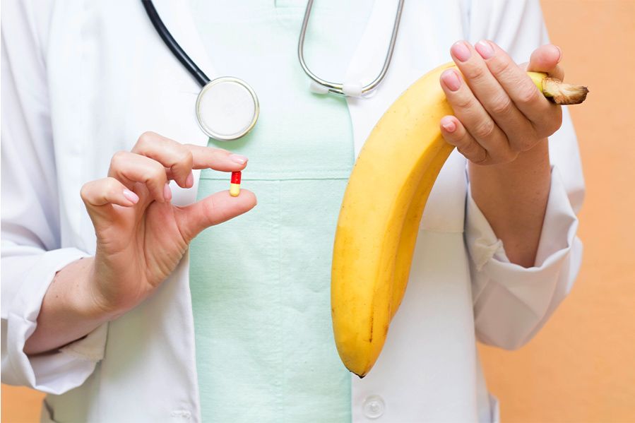 Doctor holding banana and pill concept of penis enlargement