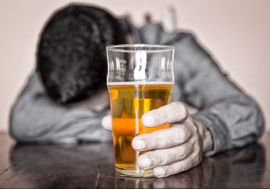 A man using self-medication to deal with stress by drinking alcohol.
