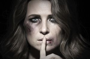 A domestic violence victim with her hand to her lips