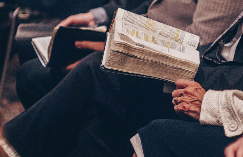 An Elderly Woman Reads the Bible at Church