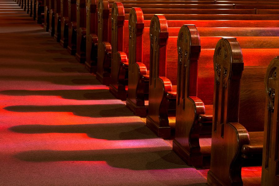 stained glass reflection on empty church pews