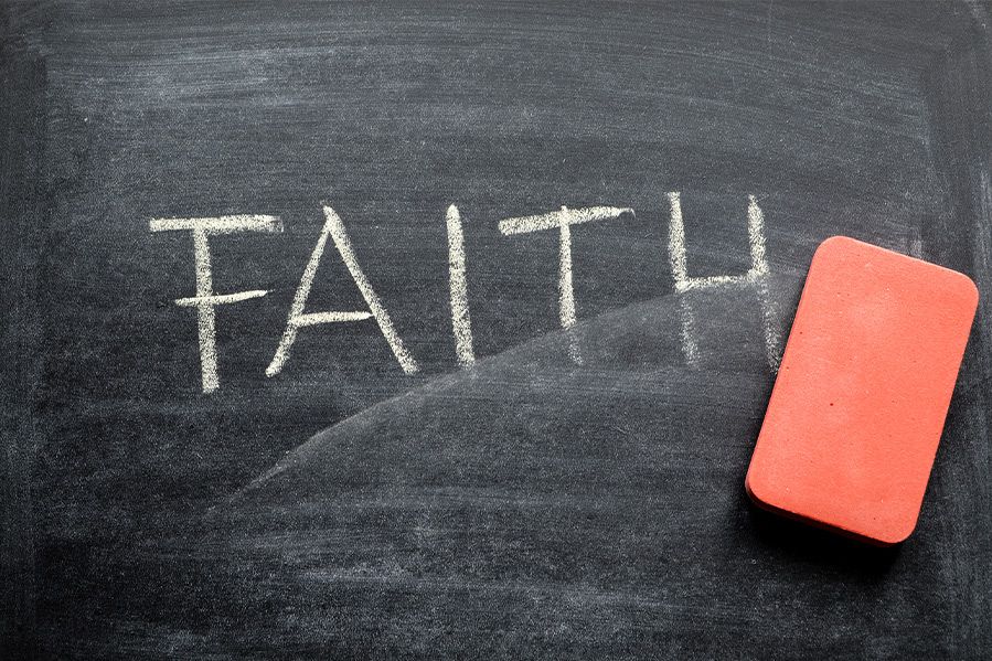 hand erasing faith off chalk board