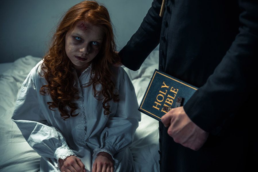 man performing exorcism on little girl
