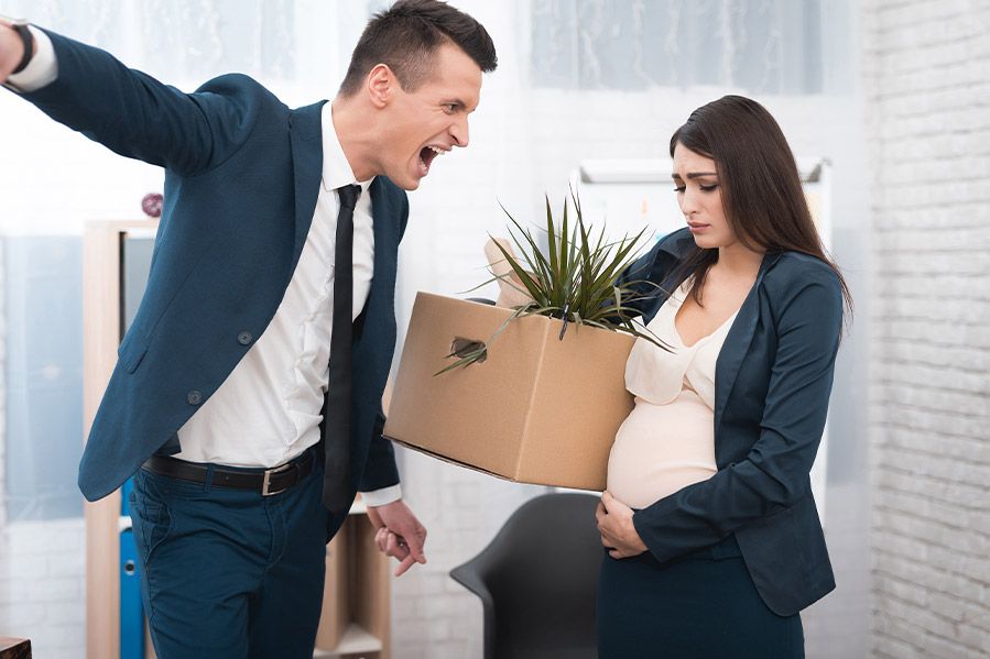 pregnant woman in office being fired by male boss