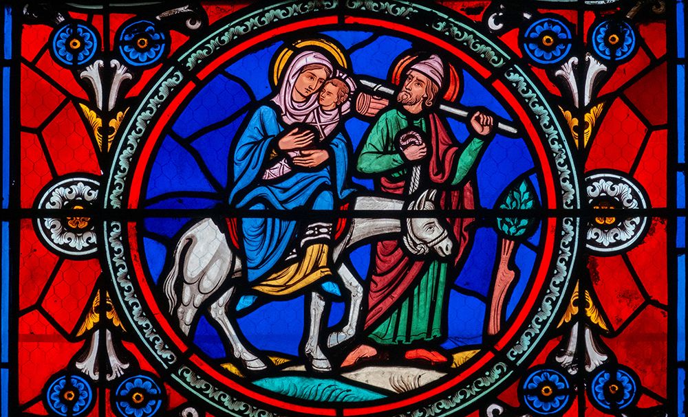 A stained glass depiction of Joseph, Mary, and Jesus fleeing into Egypt to escape Herod.