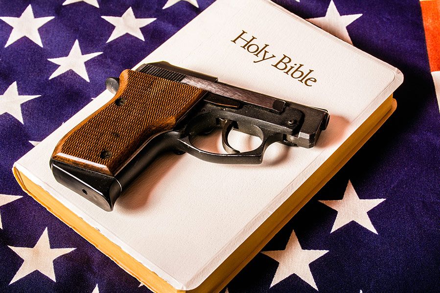 handgun atop bible sitting on american flag