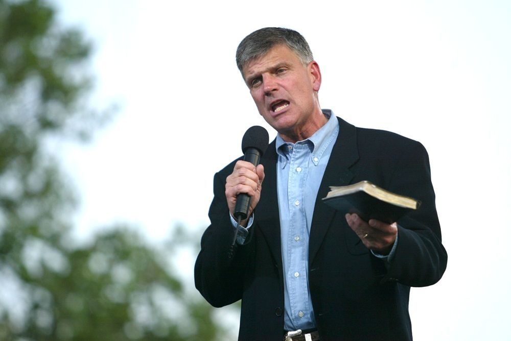 Evangelist Franklin Graham holding a Bible and speaking